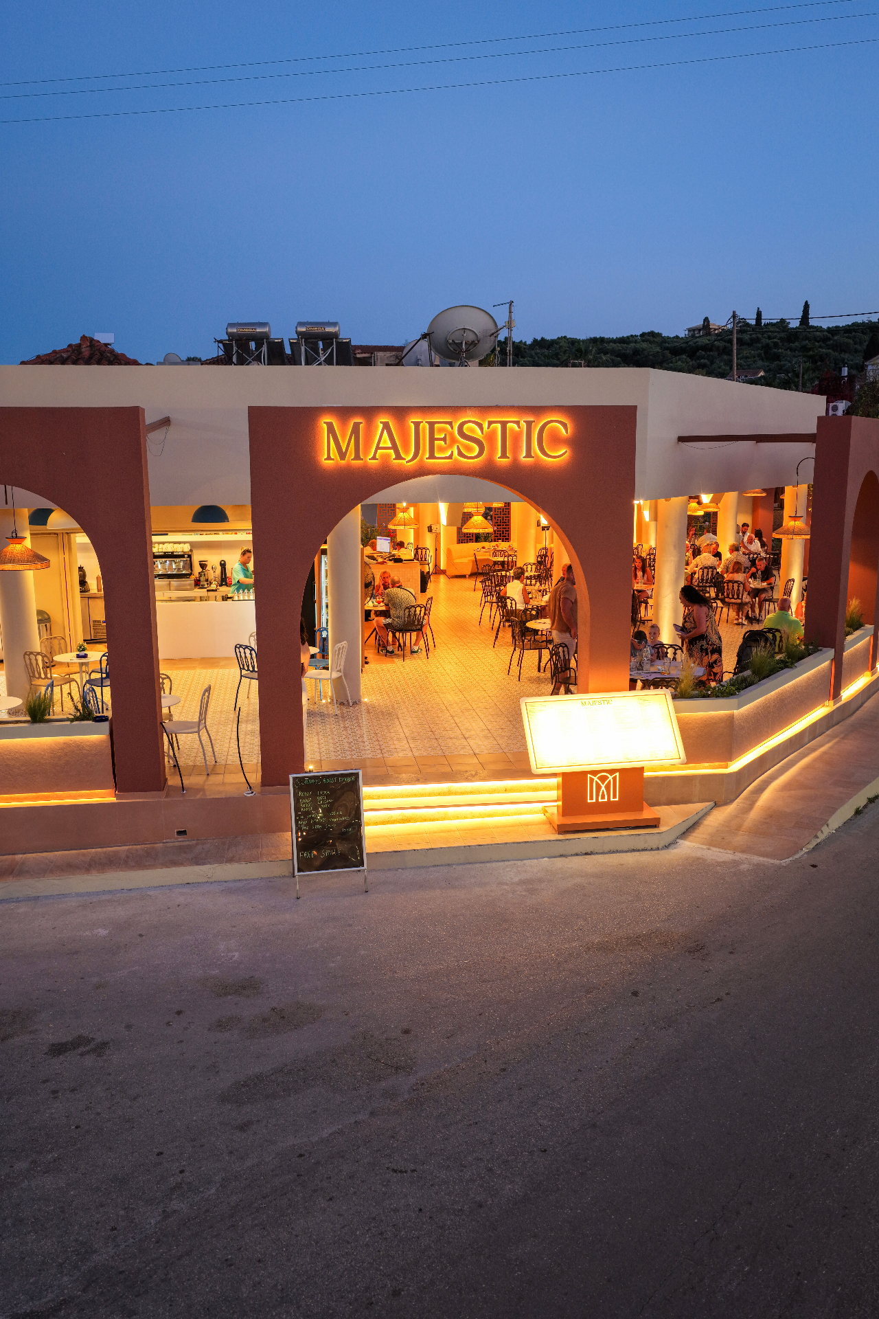 Majestic restaurant illuminated entrance at dusk in Tsilivi